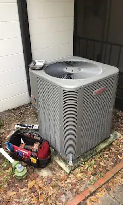 Technician checking refrigerant levels on an air conditioning unit, illustrating the comprehensive seasonal AC check process
